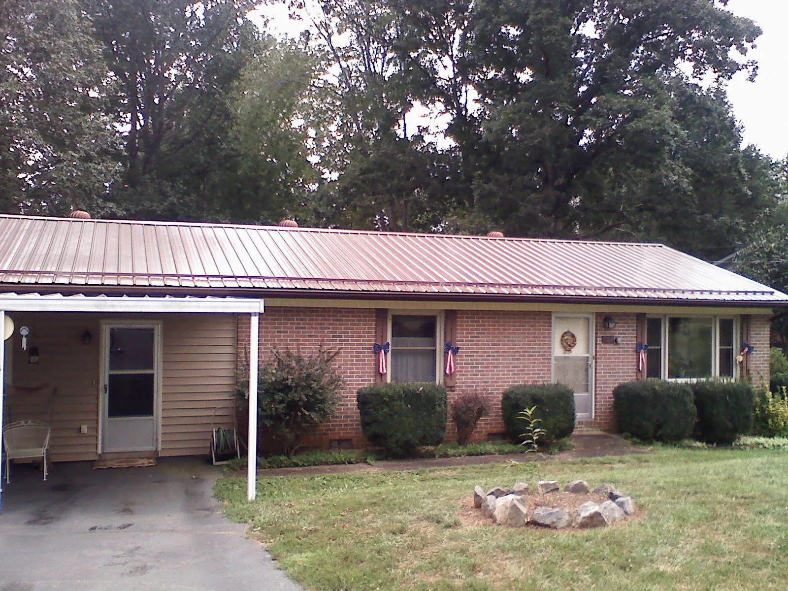 Bronze metal roof and carport on a brick ranch home — Roof Repair work by our crew in Fort Bragg